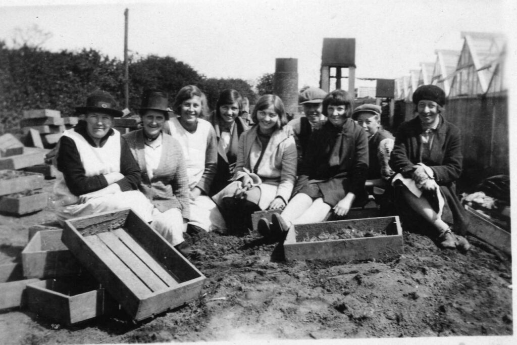 Image showing ffruit pickers and the range of greenhouses on the farm